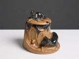 une figurine en céramique représentant un chat et une souris posée sur une table
