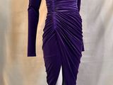 Le mannequin porte une robe violette à manches longues.