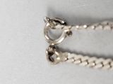 a silver chain that has a heart on it