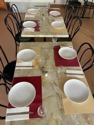 une longue table sur laquelle sont disposés des couverts et des couverts