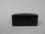 une petite boîte noire posée sur une surface blanche