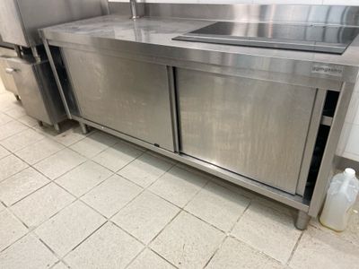 a large stainless steel kitchen with a sink and refrigerator