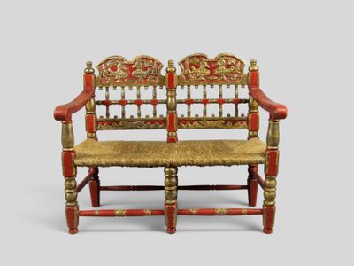 un banc rouge et doré avec une assise dorée