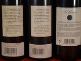 several bottles of wine are lined up on a shelf