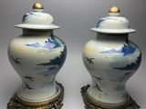 pair of blue and white vases with lids on stands