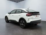the rear end of a white car in a white room