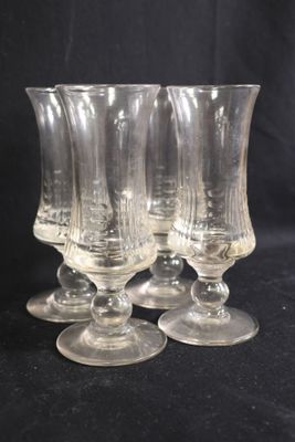 quatre verres à vin transparents posés sur une table noire
