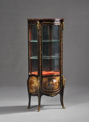 une vitrine ancienne avec une porte vitrée et des moulures dorées