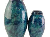 deux vases bleus posés l'un à côté de l'autre sur une surface blanche