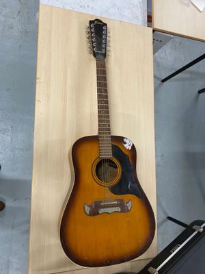 une guitare accrochée au mur à côté d'un étui à guitare