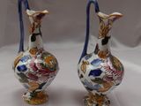 Deux vases ornés de motifs floraux sont posés sur une surface blanche.