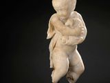 a white marble statue of a child holding a baby