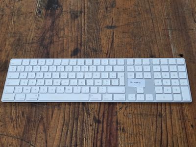 un clavier blanc posé sur une table en bois