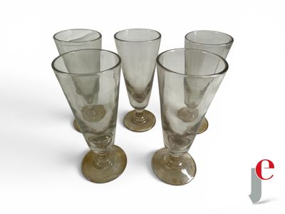 four empty wine glasses sitting on a white surface