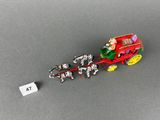 a small toy truck with a dog pulling a carriage