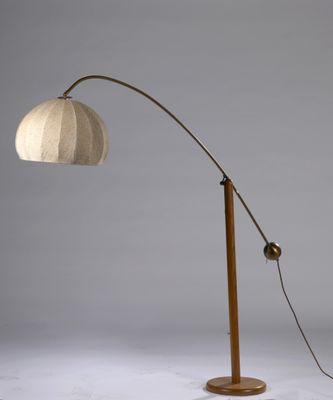a wooden floor lamp with a white shade on top of it