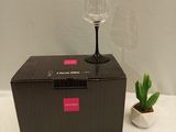 a wine glass sitting on top of a box next to a cactus plant
