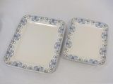 two plates with blue and white designs on them sitting on a table