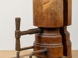 an old wooden machine with a wooden handle on a table