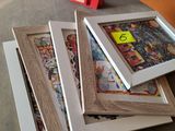 three picture frames sitting on a table with a red box