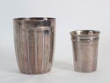 une coupe en argent à côté d'une autre coupe en argent sur une table
