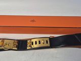 une boîte orange avec une ceinture noire et une boucle dorée