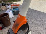 an orange and white traffic cone sitting on the side of the road