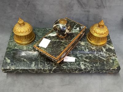 a marble table with a book and two candles on top of it