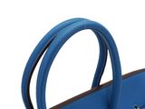 the large blue bag is sitting on a white surface