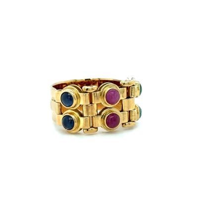 a close up of a gold ring with multi colored stones