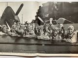 black and white photo of a group of people in front of a plane