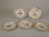 quatre assiettes ornées de motifs floraux et d'une bordure dorée sur fond blanc