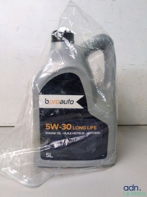 un gros plan sur une bouteille en plastique d'huile moteur posée sur une table