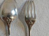 deux cuillères et une fourchette en argent sur une table