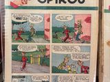 deux bandes dessinées exposées sur une table rouge