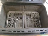 a close up of a fryer oven with two pans inside of it