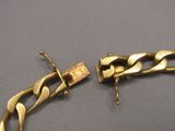 un bracelet en or et une chaîne en or posés sur une table