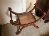 a wooden chair that has a woven seat on it