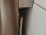 a close up view of a stainless steel refrigerator with a hose attached to it