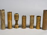 quatre vases en laiton de styles différents posés sur une surface blanche