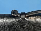 a close up of a black purse with a bow on it