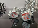 two silver metal dice holders with red writing on them
