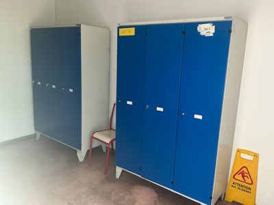 two blue and white lockers and a chair in a room