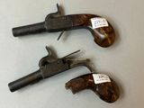 two old guns are sitting on a table next to each other