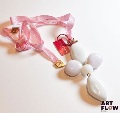 un collier blanc auquel est attaché un ruban rose