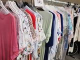 beaucoup de chemises suspendues à un portant dans un magasin