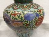 a vase with a floral design on it sitting on a table