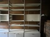 a room with a bed, shelves, and a desk in it