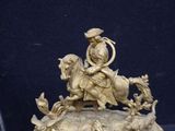 a statue of a man riding on a horse with a dog