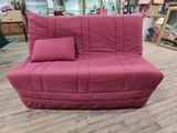 un canapé-futon avec des coussins dessus, dans une pièce
